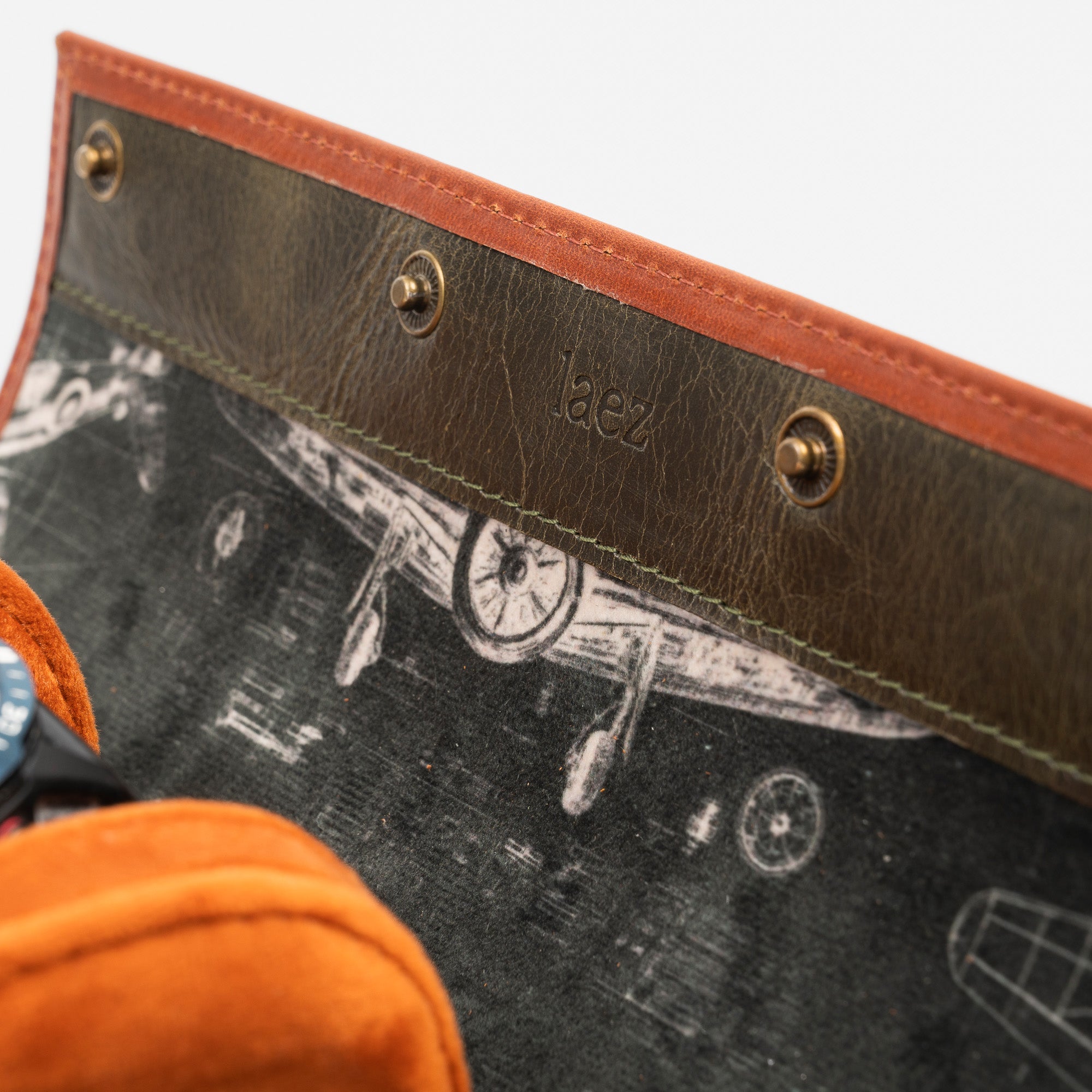 A leather travel watch roll displaying three elegant watches within a stylish case.