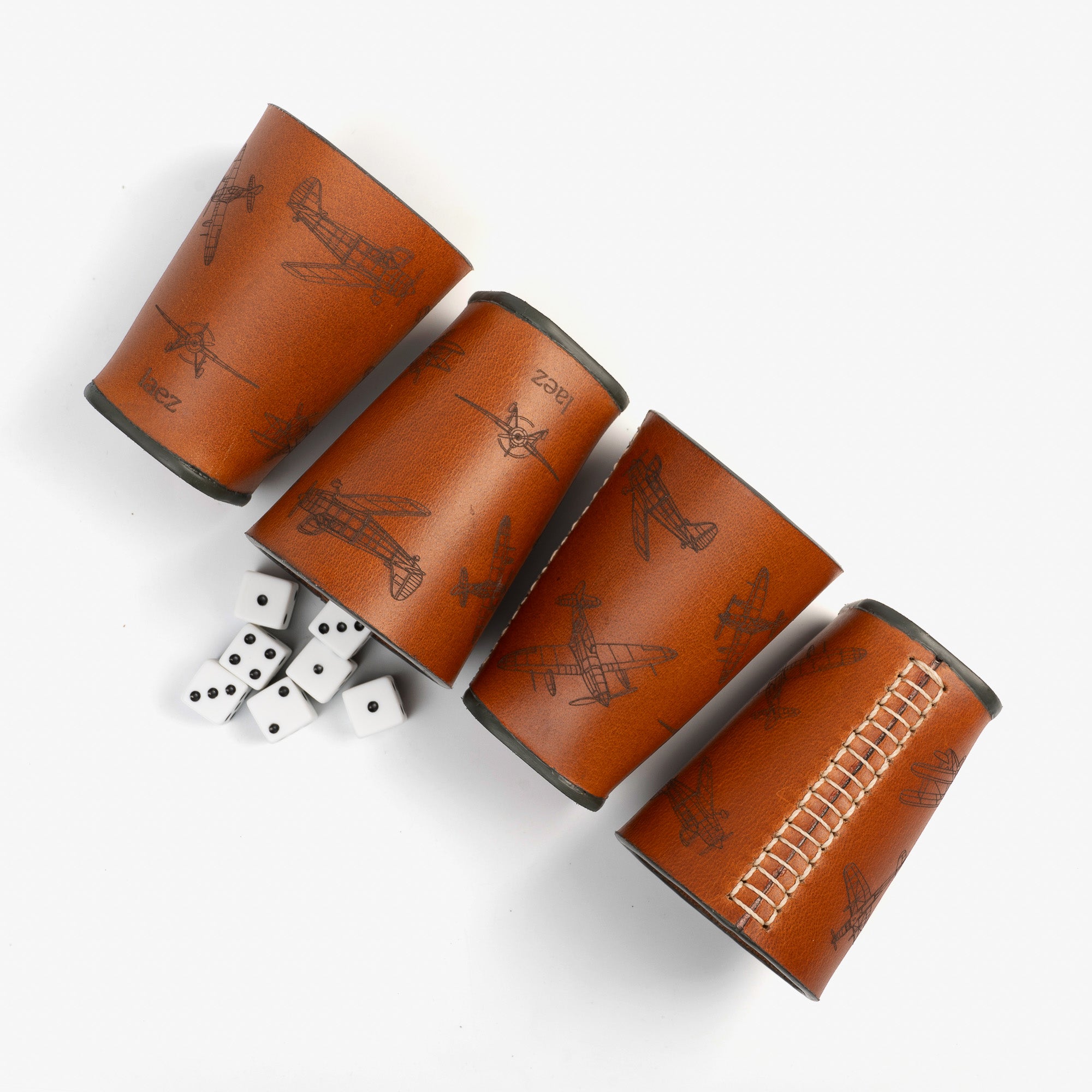 Four dice cups arranged neatly beside a cup filled with colorfu dice