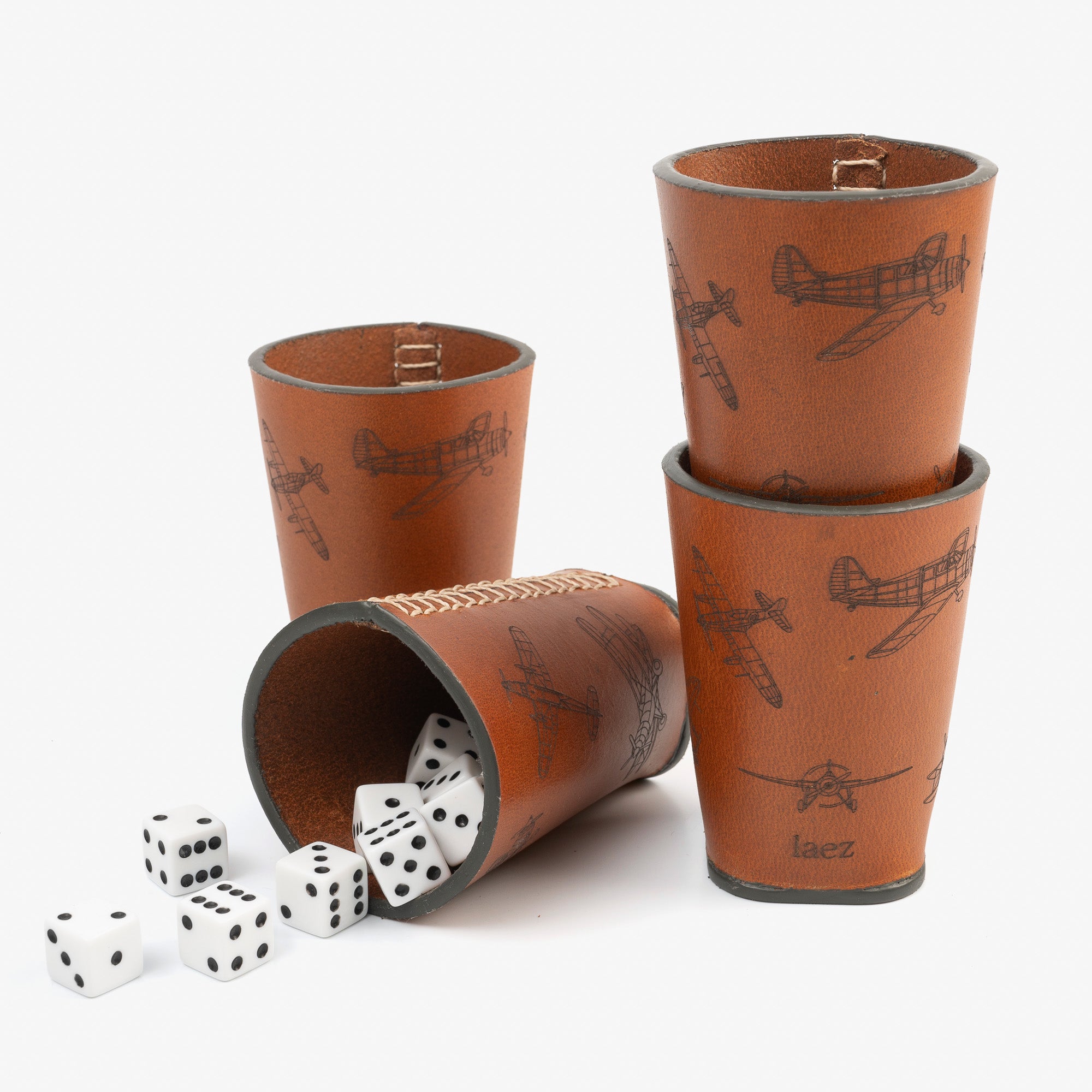 Four dice cups arranged neatly beside a cup filled with colorfu dice