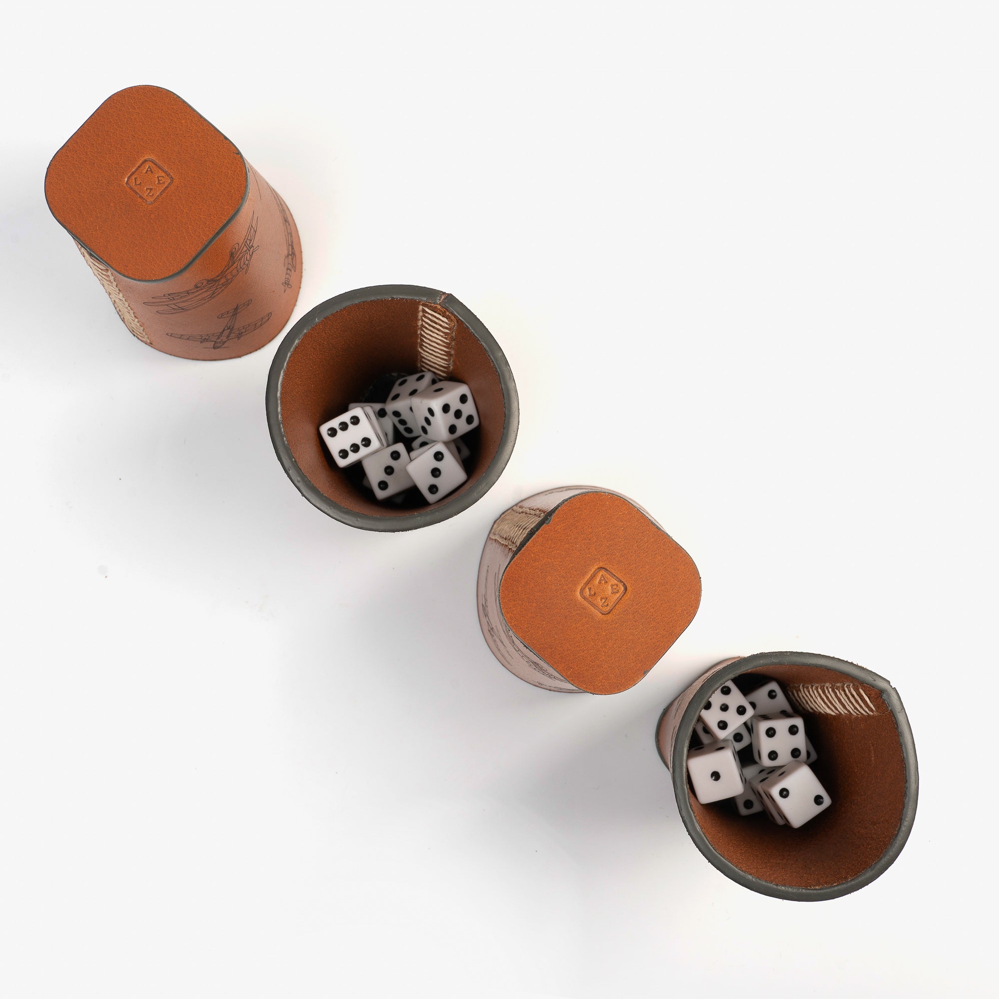 Four dice cups stacked up beside many dices