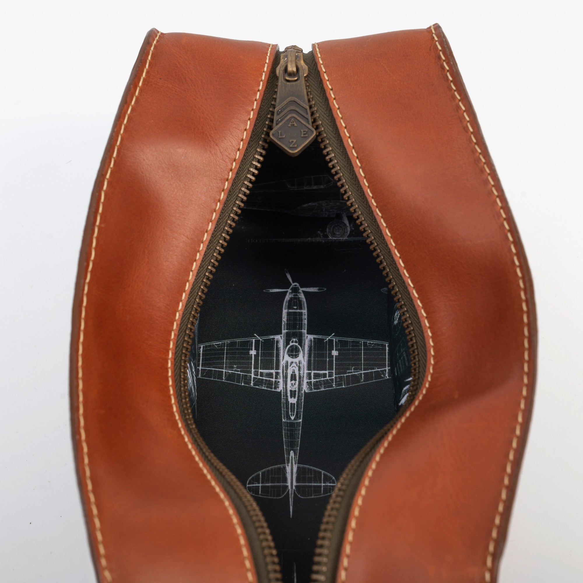 A brown leather travel pouch containing a toothbrush, toothpaste, and various toiletry items for personal care.