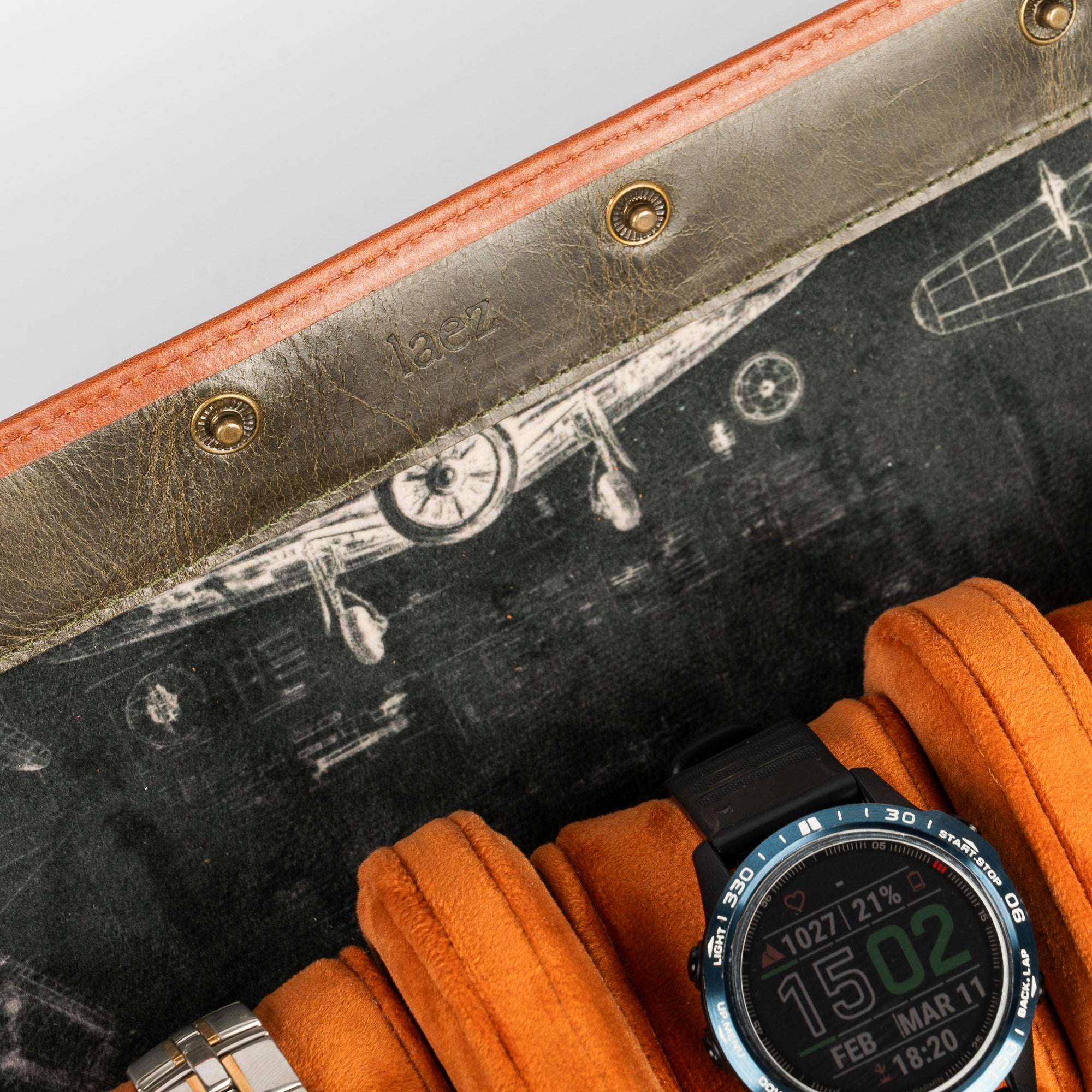 A leather travel watch roll displaying three elegant watches within a stylish case.