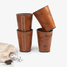  Four dice cups arranged neatly beside a bag filled with dice, ready for a game night.