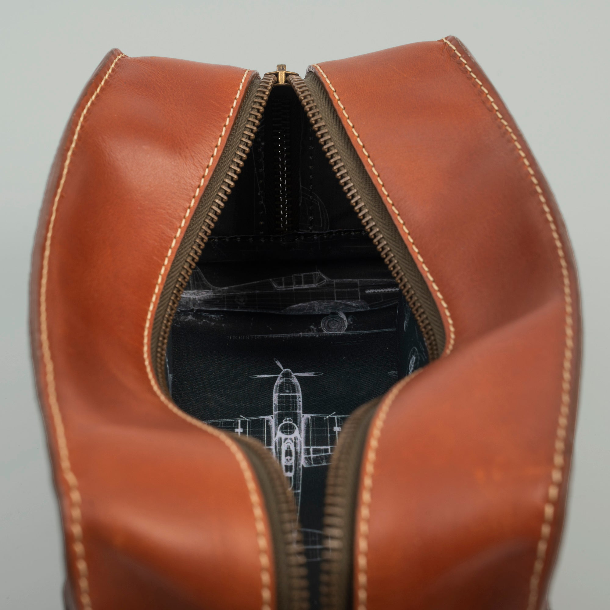 A brown leather travel pouch containing a toothbrush, toothpaste, and various toiletry items for personal care.