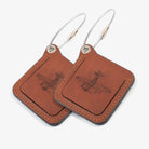 Two leather luggage tags with metal rings, elegantly designed for travel organization and personalization.