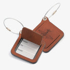 Two leather luggage tags with metal rings, elegantly designed for travel organization and personalization.
